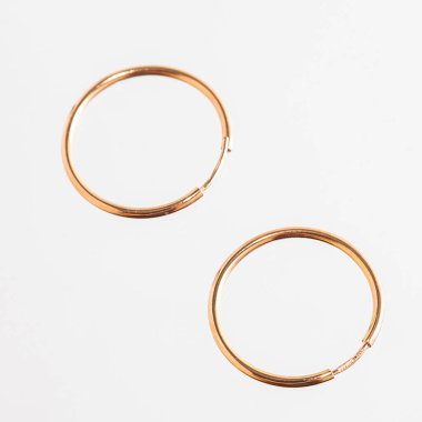 Beyaz arka planda izole edilmiş bir çift altın küpe.