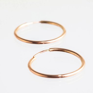 Beyaz arka planda izole edilmiş bir çift altın küpe.