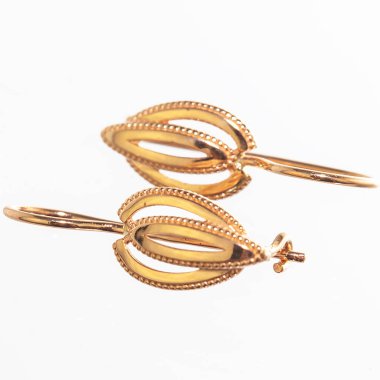 Beyaz arka planda izole edilmiş bir çift altın küpe.