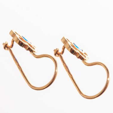 Beyaz arka planda izole edilmiş bir çift altın küpe.