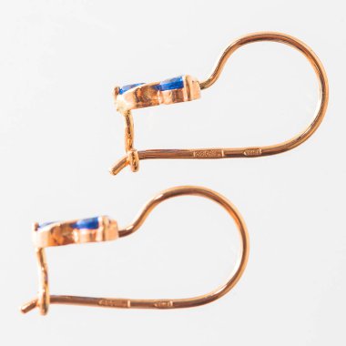 Beyaz arka planda izole edilmiş bir çift altın küpe.