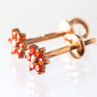 Beyaz arka planda izole edilmiş bir çift altın küpe.