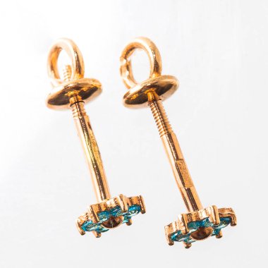 Beyaz arka planda izole edilmiş bir çift altın küpe.