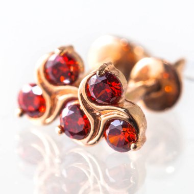 Beyaz arka planda izole edilmiş bir çift altın küpe.