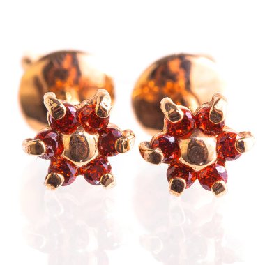 Beyaz arka planda izole edilmiş bir çift altın küpe.