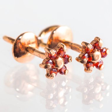 Beyaz arka planda izole edilmiş bir çift altın küpe.