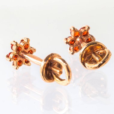 Beyaz arka planda izole edilmiş bir çift altın küpe.