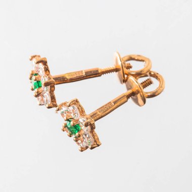 Beyaz arka planda izole edilmiş bir çift altın küpe.