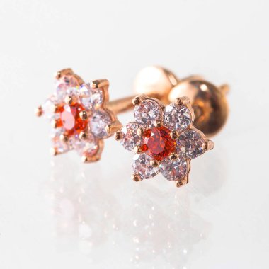 Beyaz arka planda izole edilmiş bir çift altın küpe.