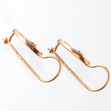 Beyaz arka planda izole edilmiş bir çift altın küpe.