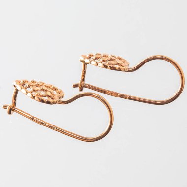 Beyaz arka planda izole edilmiş bir çift altın küpe.