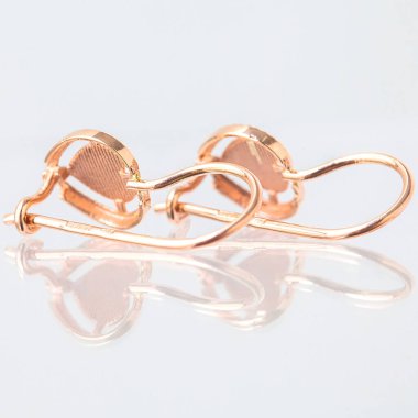 Beyaz arka planda izole edilmiş bir çift altın küpe.