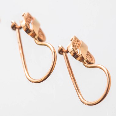 Beyaz arka planda izole edilmiş bir çift altın küpe.