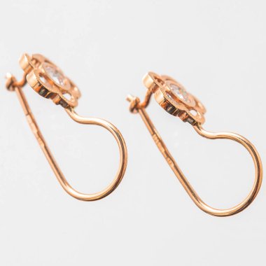 Beyaz arka planda izole edilmiş bir çift altın küpe.