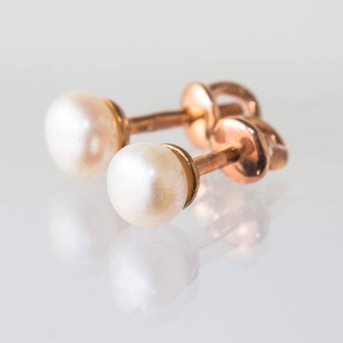 Beyaz arka planda izole edilmiş bir çift altın küpe.