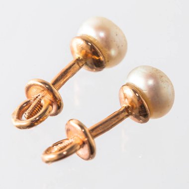 Beyaz arka planda izole edilmiş bir çift altın küpe.