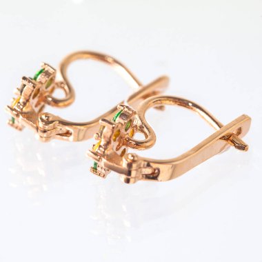 Beyaz arka planda izole edilmiş bir çift altın küpe.