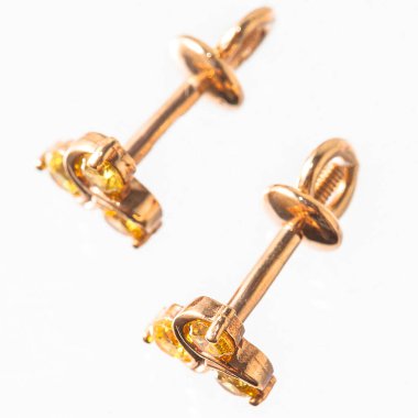 Beyaz arka planda izole edilmiş bir çift altın küpe.