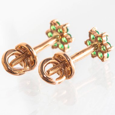 Beyaz arka planda izole edilmiş bir çift altın küpe.