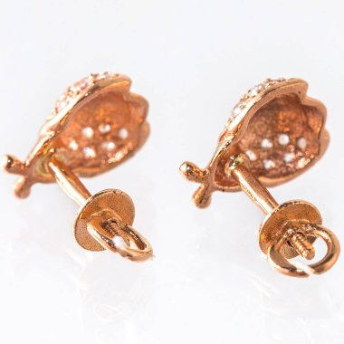 Beyaz arka planda izole edilmiş bir çift altın küpe.