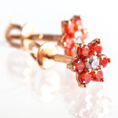 Beyaz arka planda izole edilmiş bir çift altın küpe.