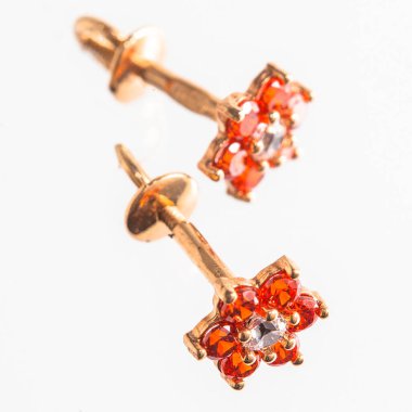 Beyaz arka planda izole edilmiş bir çift altın küpe.