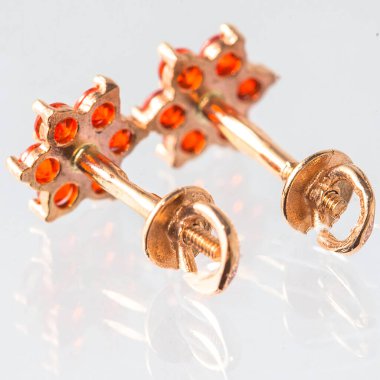 Beyaz arka planda izole edilmiş bir çift altın küpe.