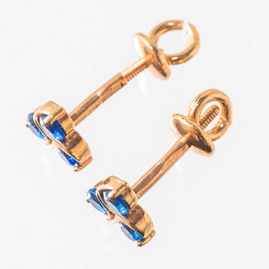 Beyaz arka planda izole edilmiş bir çift altın küpe.