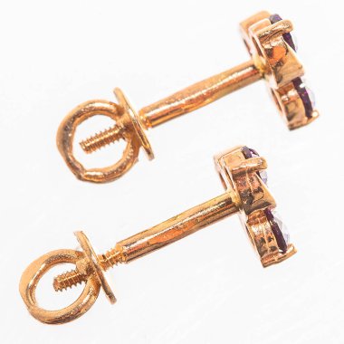 Beyaz arka planda izole edilmiş bir çift altın küpe.