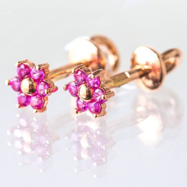 Beyaz arka planda izole edilmiş bir çift altın küpe.