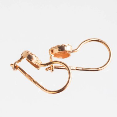 Beyaz arka planda izole edilmiş bir çift altın küpe.