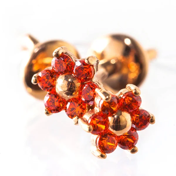 Beyaz arka planda izole edilmiş bir çift altın küpe.