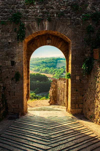 Eski ortaçağ şehir kapısı. Günbatımında İtalyan Toskana 'da bir ortaçağ şehrinin kapısı