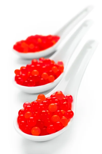 Caviar rojo sobre cucharas de porcelana despejadas —  Fotos de Stock