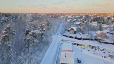 Drone flight through snowy forest at sunset
