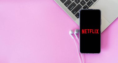 Bangkok, Tayland - 6 Eylül 2021: Netflix 'e bağlı kulaklıklı cep telefonu klavyesine yerleştirilmiş, Netflix küresel bir televizyon ve film sağlayıcısı