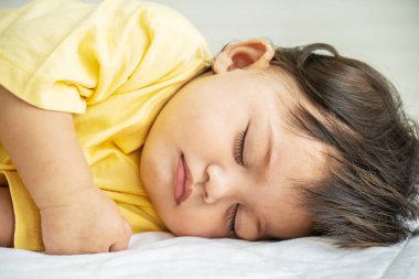 Sevimli, küçük bebek portresi ya da yatakta rahatça uyuyan bebek. Sevimli yeni doğan çocuk konsepti