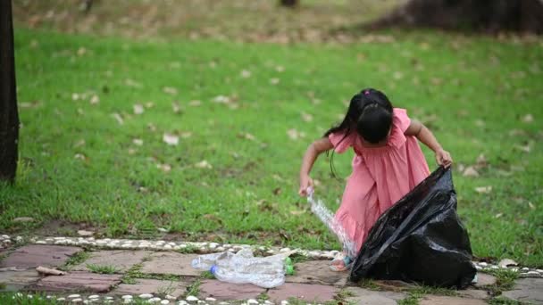 亚洲小女孩白天在公园捡塑料垃圾环境污染的概念 — 图库视频影像