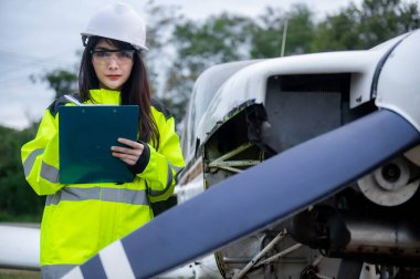 Teknisyen uçağın motorunu tamir ediyor, kadın uzay mühendisi uçak motorlarını kontrol ediyor.