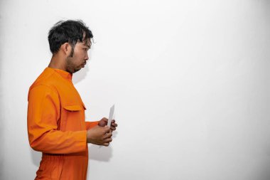 Hapishane üniformalı Asyalı yakışıklı adamın portresi.