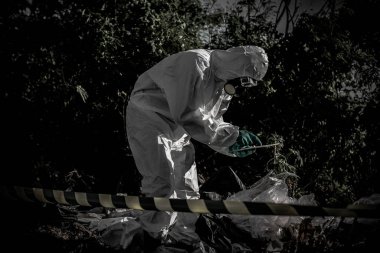 Kimyasal koruma giysisi giyen Asyalı bilim adamı tehlikeli bölgede çalışıyor. Çin 'den Corona virüsü salgını için örnek topluyor..