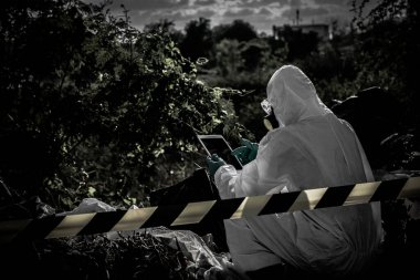 Kimyasal koruma giysisi giyen Asyalı bilim adamı tehlikeli bölgede çalışıyor. Çin 'den Corona virüsü salgını için örnek topluyor..