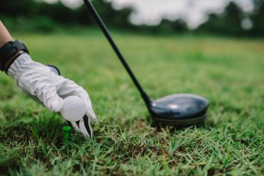Golf kulübünde golf tahtası tutan Asyalı bir kadının portresi.
