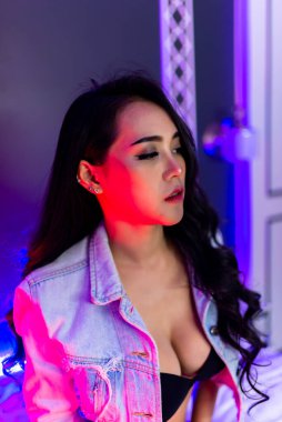 Yatak odasında neon ışığı olan güzel seksi Asyalı kadın portresi.