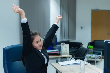 Asyalı bir memur, Taylandlı bir iş kadınının sıkı çalışmaktan yorgun düştüğü arka taraftan ofis masasına uzanıyor.