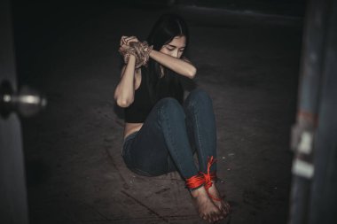 Asyalı rehine kadın. Gece vakti iple bağlanmış.