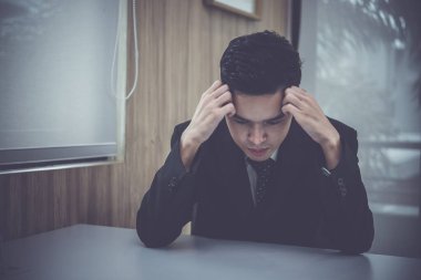 Asyalı işadamı ofiste çalışmayı düşünüyor, Tayland işçisi yarın için bir proje düşünüyor.