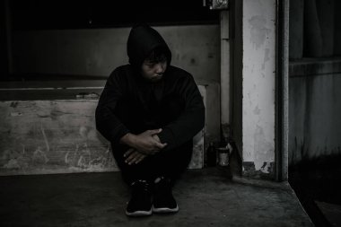 Asyalı üzgün bir adamın portresi, yerde oturan uyuşturucu bağımlısı, flakka ilacı, zombi uyuşturucusu