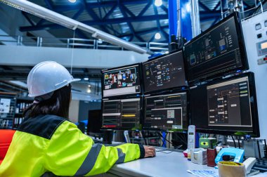 Yüksek performanslı bilgisayar mühendisi. Büyük fabrikada bir sürü monitörü var.