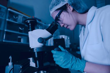 Laboratuvarda çalışan Asyalı bilim adamı, mikroskopi yoluyla koronavirüsün yeni türlerini önlüyor ve yok ediyor.